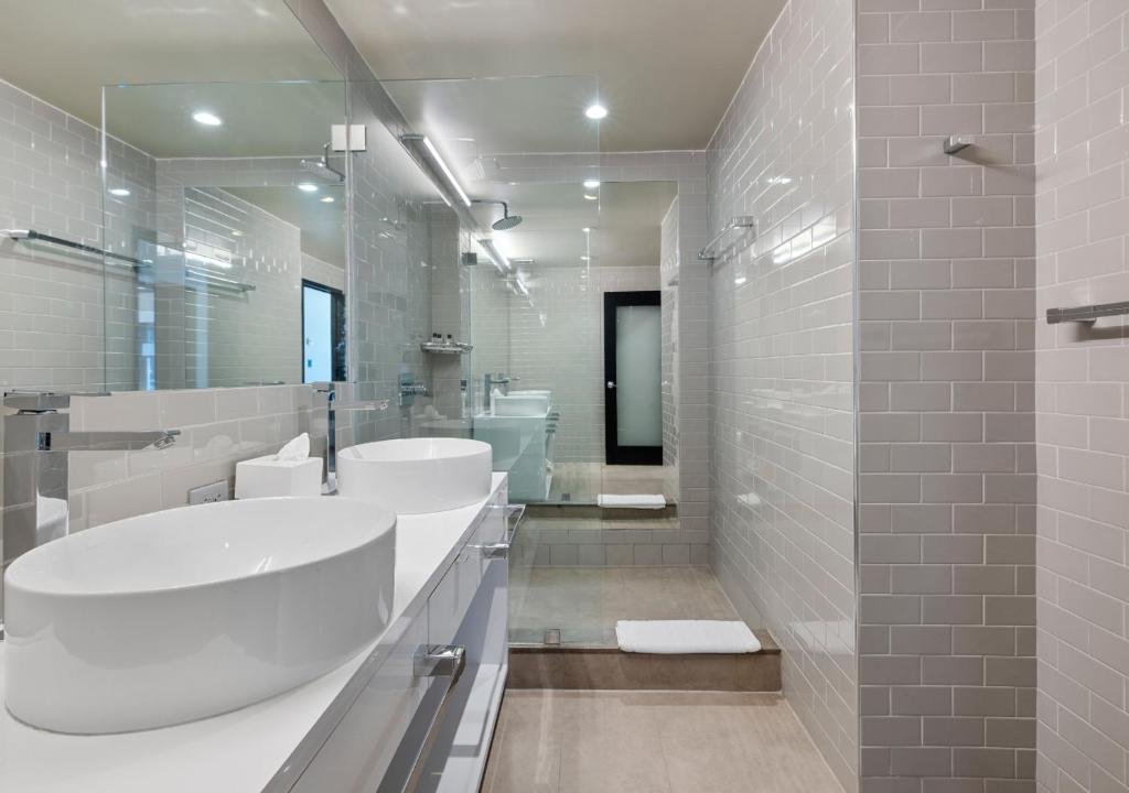 Bathroom with double sinks and shower