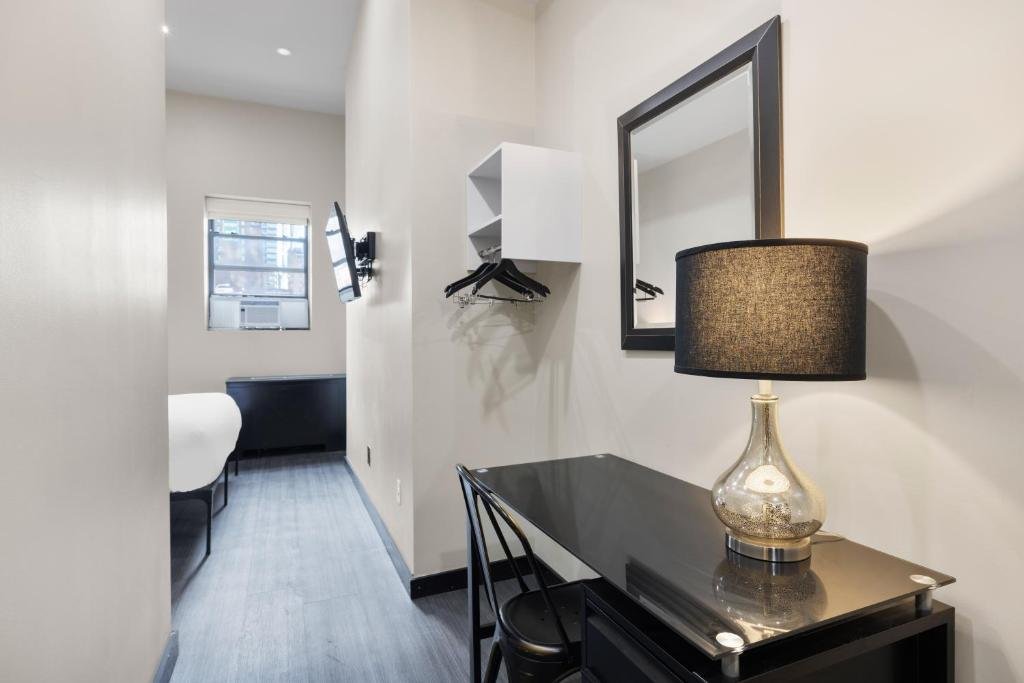 Compact room with desk, mirror, and lamp